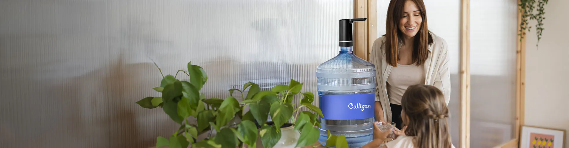 Obraz kobiety i dziecka przy niebieskim dystrybutorze wody Culligan w przytulnym wnętrzu